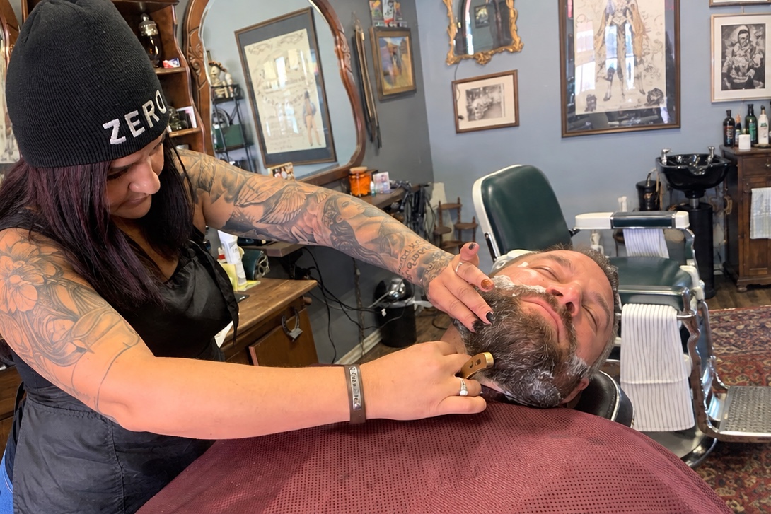 Elizabeth performing a straight razor shave at Truly Blessed Barber Studio in Winchester, California